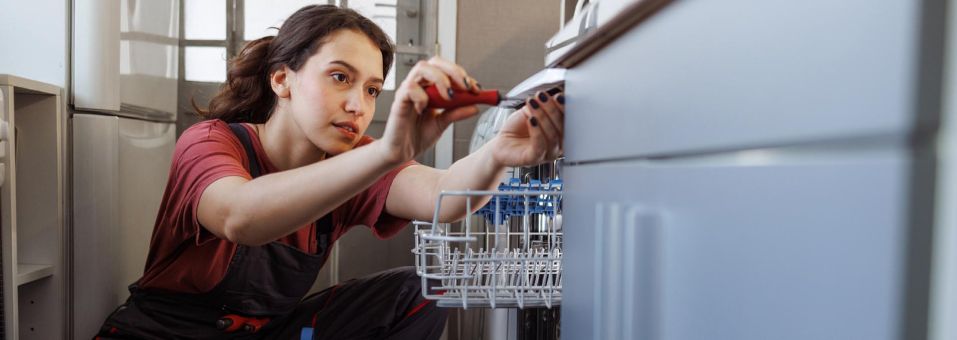 Une réparatrice installant le lave-vaisselle