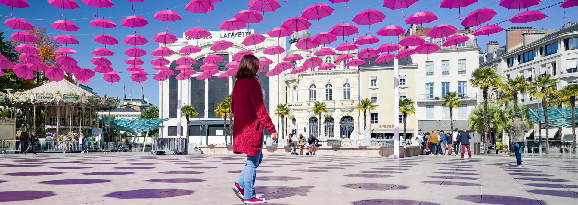 parapluies roses place Clemenceau à Pau avec passante 