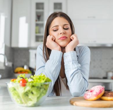 L’adolescente choisit entre les beignets et la salade de légumes