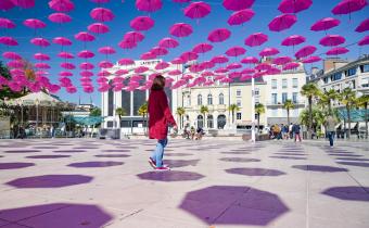 parapluies roses place Clemenceau à Pau avec passante 