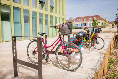 Une personne en train de garer son vélo devant l'école Henri IV